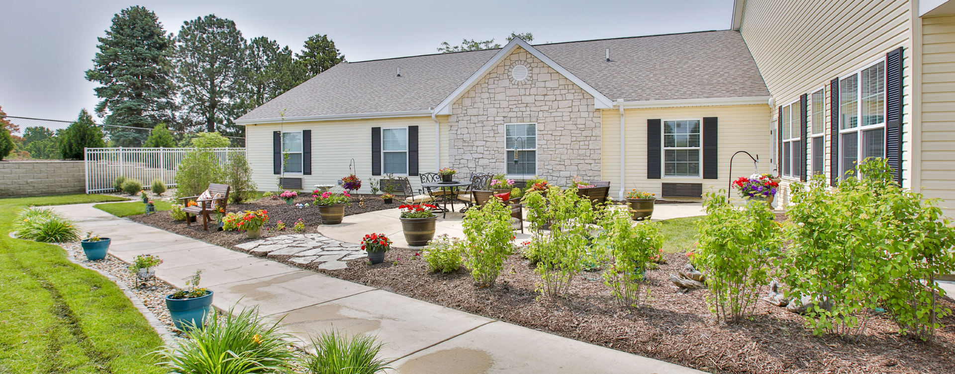 Residents with dementia can enjoy a traveling path, relaxed seating and raised garden beds in the courtyard at Bickford of Bloomington