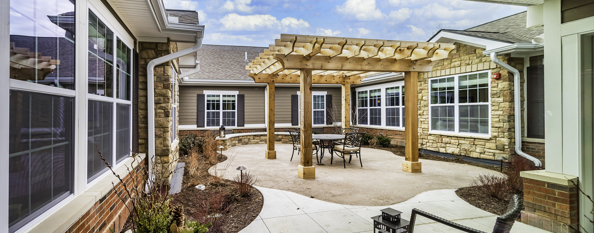 Residents with dementia can enjoy a traveling path, relaxed seating and raised garden beds in the courtyard at Bickford of Canton