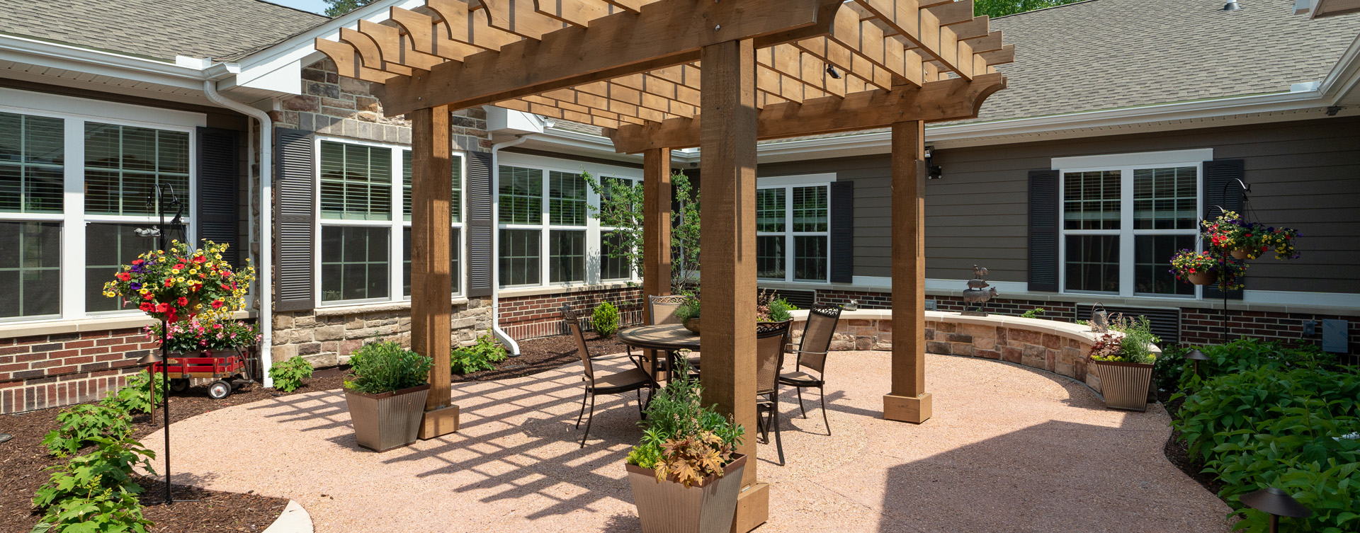 Residents with dementia can enjoy a traveling path, relaxed seating and raised garden beds in the courtyard at Bickford of Chesapeake