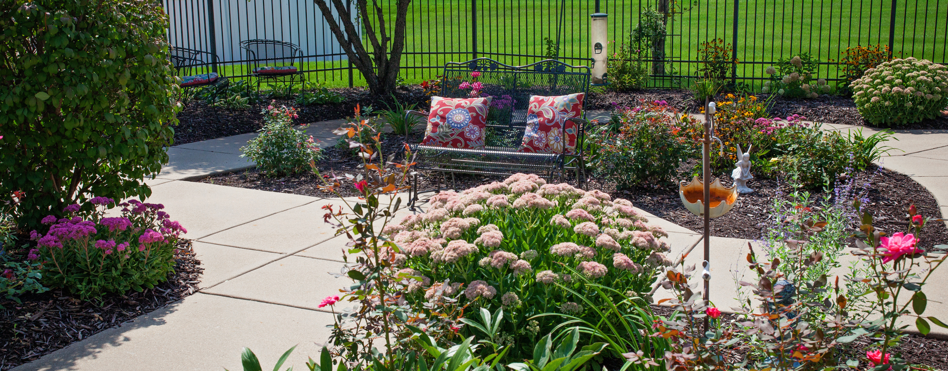 Residents with dementia can enjoy a traveling path, relaxed seating and raised garden beds in the courtyard at Bickford of Marion