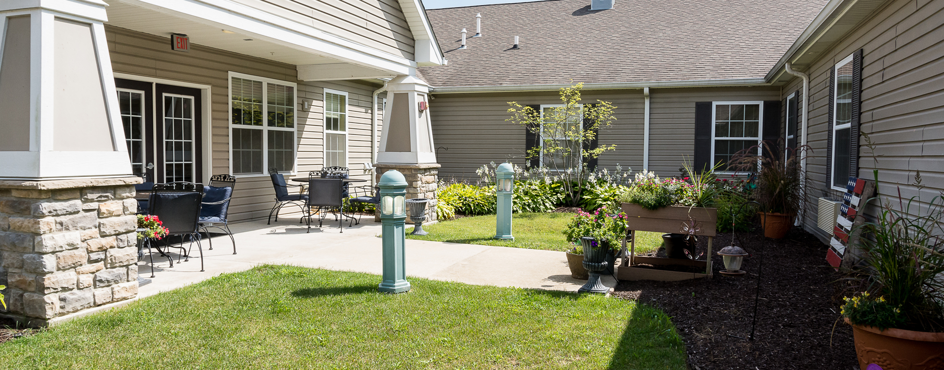 Residents with dementia can enjoy a traveling path, relaxed seating and raised garden beds in the courtyard at Bickford of Oswego