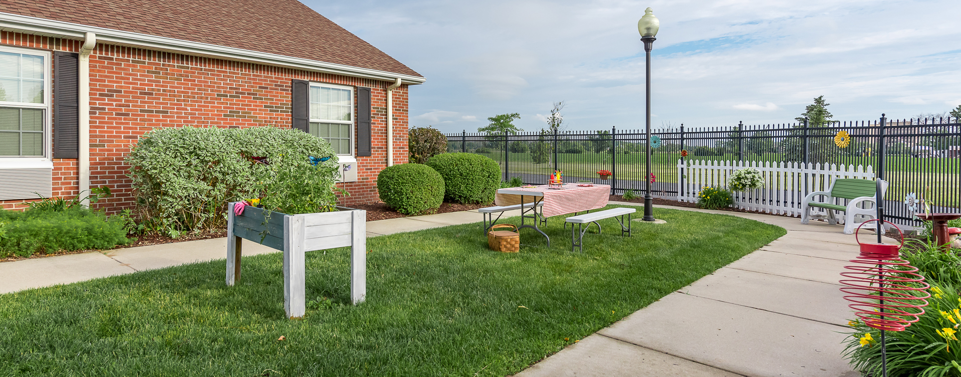 Residents with dementia can enjoy a traveling path, relaxed seating and raised garden beds in the courtyard at Bickford of Saginaw Township